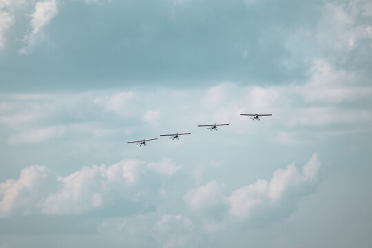 Group of ViS-3 KhAZ-30 ultralight monoplanes performs a synchronized formation stunt at an airshow