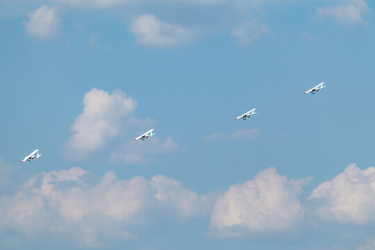 Ukrainian aviation team flies ultralight airplanes in coordinated group stunt in cloudy scenic sky