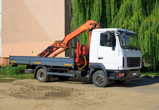 Mobile crane at a construction site, with a building under construction in the background. Construction and renovation concept.
