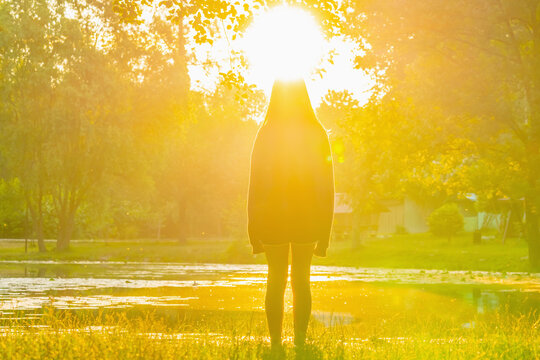 Child with a natural halo of sunlight, symbolic image of an angel, innocence and purity. Copy space for text or design.