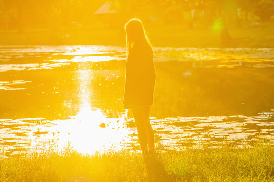 Teenage girl standing alone at sunrise, concept of adolescence, hope and new beginnings.