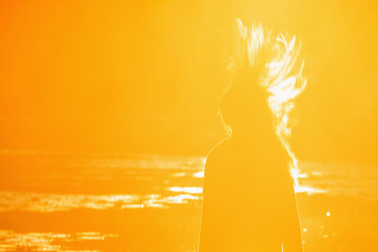 Energetic teenage girl with flying hair in golden sunrise light, concept of youth, freedom and joy of life.