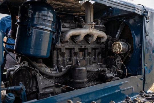 Under-the-hood view of vintage crawler tractor diesel engine showing exhaust manifold, air filter, radiator fan, and mechanical components.