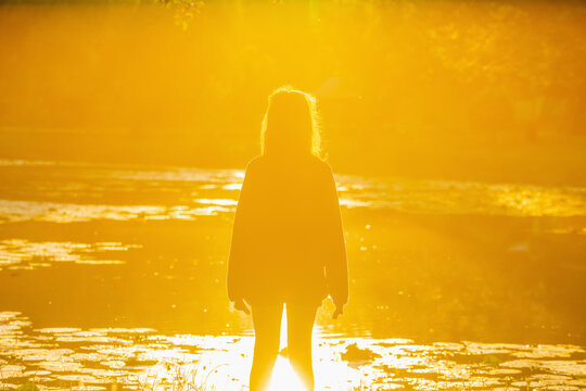 Young girl watching the morning sun, concept of hope, freedom and opportunity.