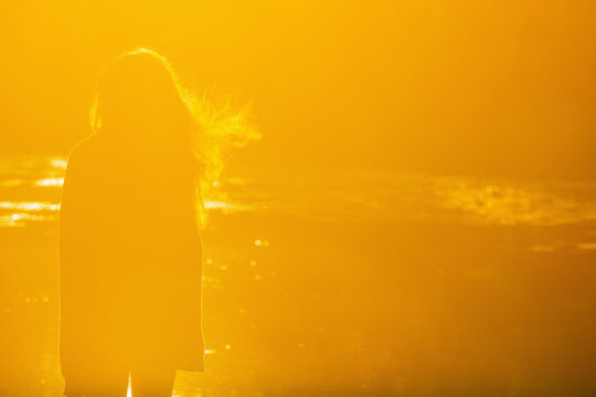 Teenage girl watching the sunrise, concept of youth, dreams and new beginnings. Copy space for text or design.