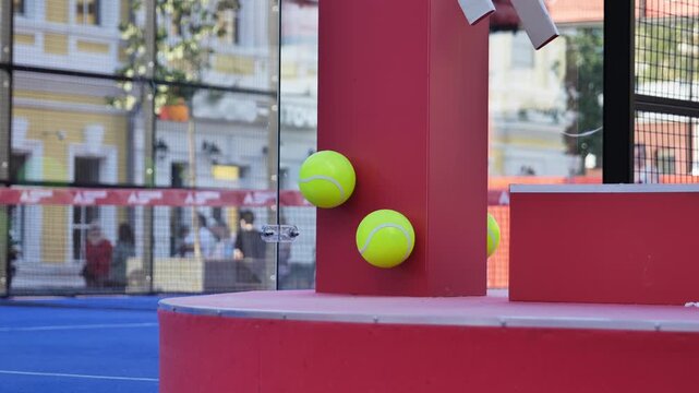 Padel or tennis balls bouncing off a red pillar on an outdoor court