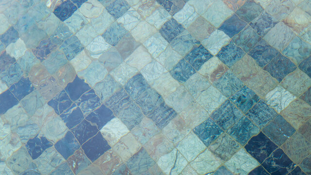 blue texture background of square mosaic tiles on floor of swimming pool