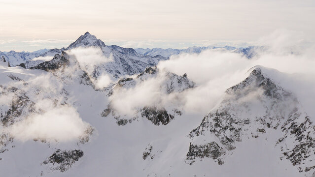 above the clouds in snow covered mountain alps