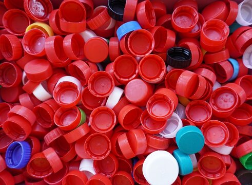 A bunch of colorful plastic bottle caps, the concept of recycling, environmental pollution, a background of plastic waste.
