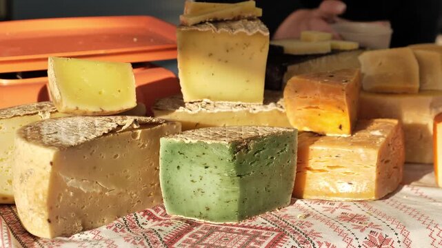 Artisan cheese assortment on a market stall, offering organic rustic dairy products