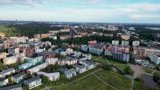 Aerial drone view of Pikku-Huopalahden Puisto and the surrounding residential areas of Pikku-Huopalahti and Ruskeasuo in Helsinki, Finland, featuring green parkland, residential buildings, roads, and 