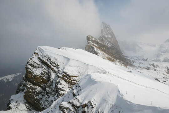 seceda mountain ridge in snow and clouds in winter, dolomites, italy