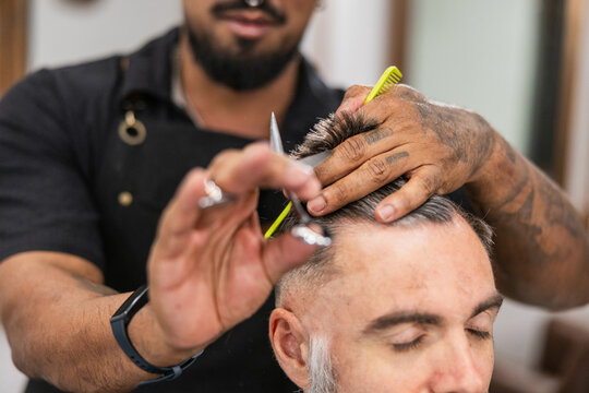 Barber cutting client's hair in barbershop