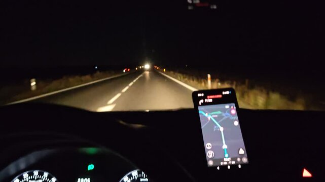 Smartphone navigation guiding night drive on empty highway
