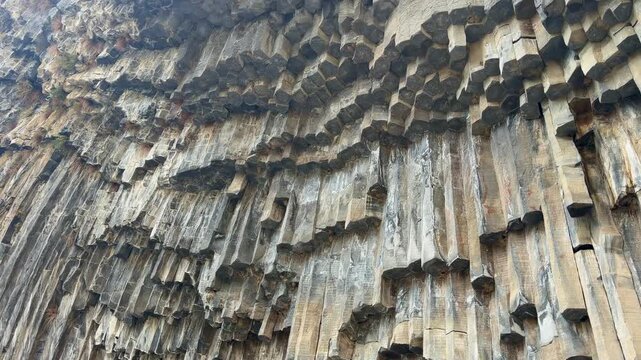 Garni, Armenia - August 26, 2026: Unique basalt rock formations display stunning geometric patterns and textures in a natural landscape surrounded by wilderness