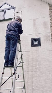 Restoring residential wall appearance with pressure washing equipment during exterior cleaning service, handheld, 4k