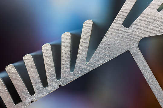 Aluminum Heat Sink in Cross Section with Finned Structure with Industrial Lighting and Metal Texture in Close Up