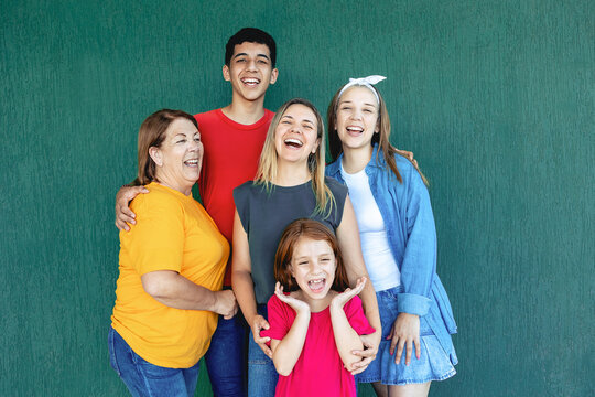 Happy multigenerational people having fun outdoors - Latin family smiling on camera - Main ocus on mother face