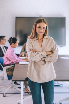 Confident Female Leader Standing in Office Conference Room During Business Meeting With Team