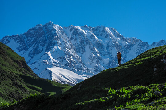 Hiker photographer Admiring Snow Mountain Peak in Svaneti Georgia, copy space