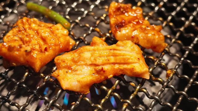 網の上で焼かれる味付けされた牛上ミノ（ホルモン焼肉）マクロ撮影