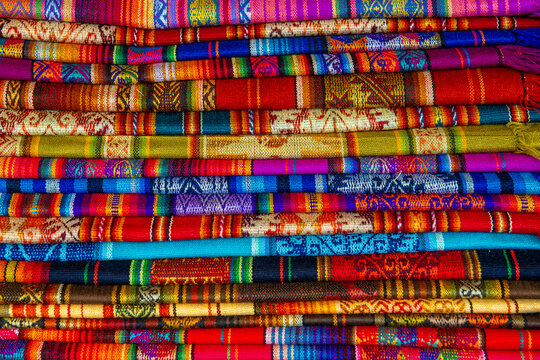 Pile of colorful Andes textiles, Otavalo market, Ecuador.