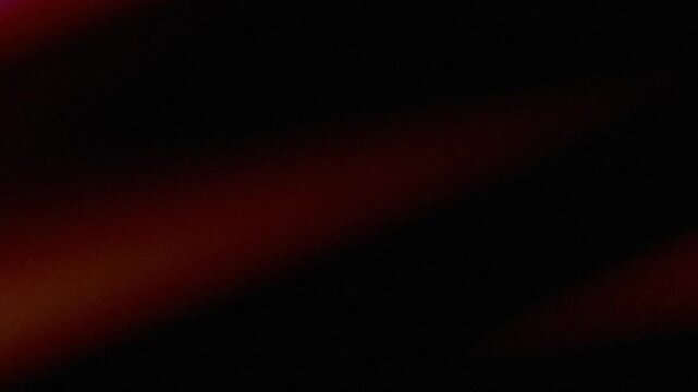 Abstract red and black background with grainy texture and diagonal light