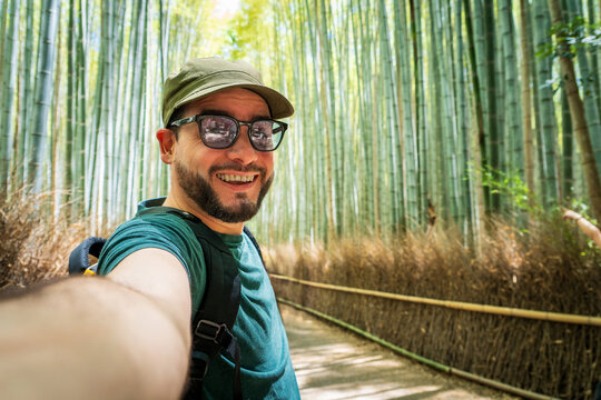 Turista disfrutando de su recorrido por Kioto, tom&aacute;ndose una selfie en el bosque de bamb&uacute; del parque arashiyama