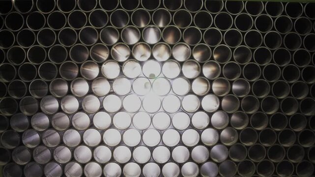 Abstract dark metal mesh texture with circular holes and bright backlighting.