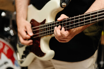 Fototapeta premium electric guitar in man hands, close-up view, young caucasian rock musician at concert