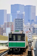 Fototapeta premium 高層ビル群を背景に高架線を走る電車