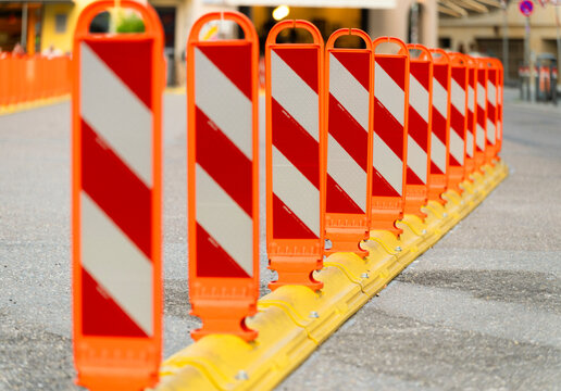 Lane separator bollard with delineator panel. Anti parking bollard in city. Row of barriers on road separating traffic zone. Crosswalk for pedestrians. Crosswalk bollard. Road traffic delineator