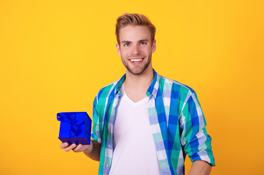 Party present box. Man on February 14. Caucasian guy hold present box for Valentines day. Happy holiday. Man with gift isolated on yellow. Birthday gift. Party on mens day. Mens day