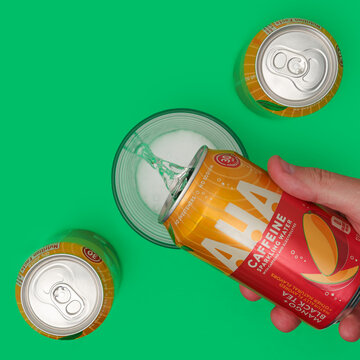 Can of AHA Sparkling Water pouring into a glass green background on August 29, 2021 in Yucca Valley, California