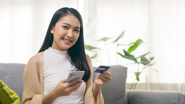 Young Asian Woman Using Smartphone and Credit Card for Online Shopping and Digital Payment