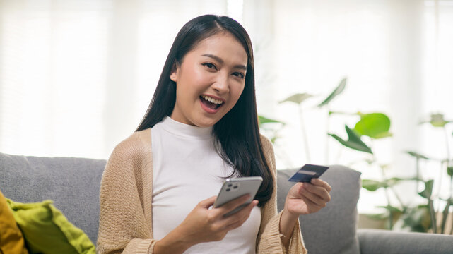 Young Asian Woman Using Smartphone and Credit Card for Online Shopping and Digital Payment