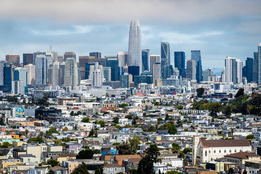 sf skyline-The prominent San Francisco skyline rises dramatically behind a sprawling expanse of densely packed urban homes and neighborhoods.