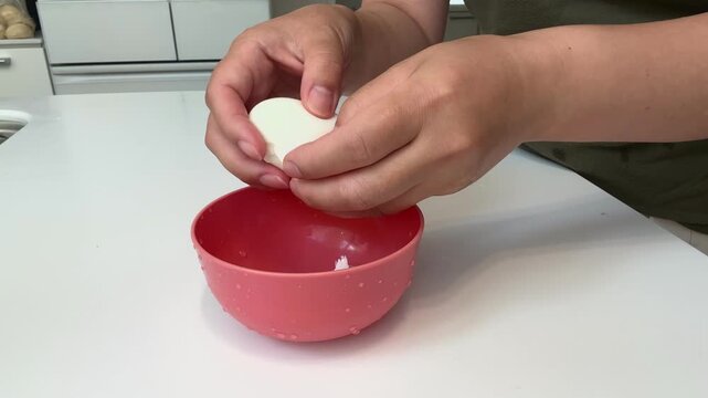 ゆで卵の殻をむく主婦