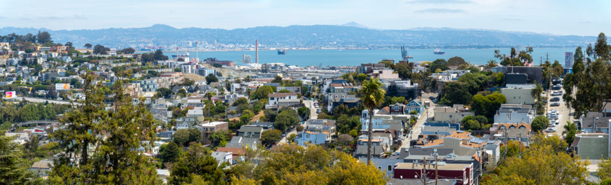 sf_Panorama-A wide-angle panoramic vista reveals San Francisco neighborhoods sloping down toward the sparkling bay and distant mountain ranges.