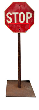 standing sign-A weathered, octagonal red stop sign stands mounted on a heavily rusted metal pole and a square metal base.
