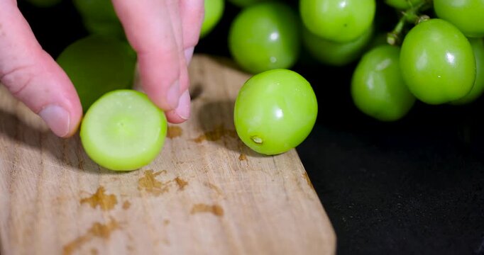Sliced green grapes with juicy flesh close-up, half of a sliced green grape without seeds