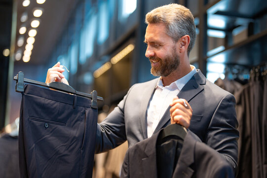 A well-tailored suit. A stylish business suit for businessman. Client chooses a suit for a business look. A portrait of a man in a classic suit. Model poses for a magazine shoot.