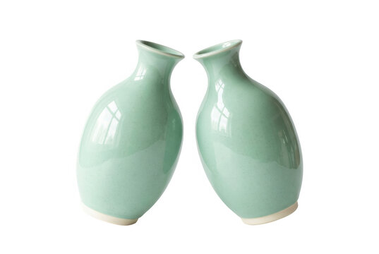 Dos jarrones de cer&aacute;mica de color verde menta con un dise&ntilde;o minimalista y elegante, colocados uno frente al otro sobre un fondo blanco puro, ideales para decoraci&oacute;n de interiores y dise&ntilde;o conceptual.