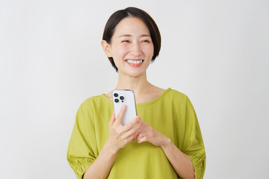 スマホを使うミドル女性　白背景