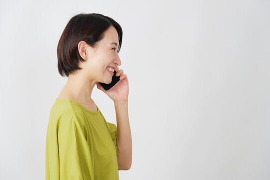 スマホで電話するミドル女性　白背景