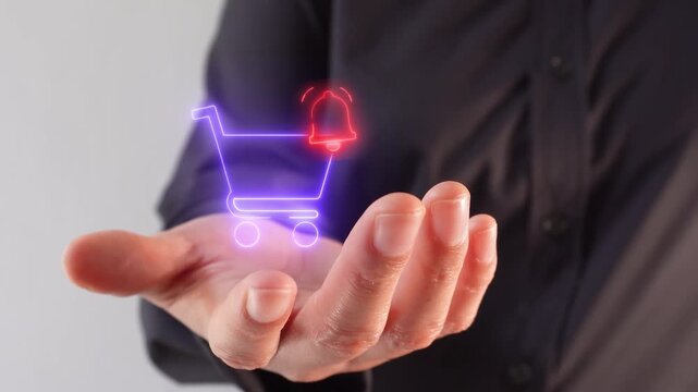 Close-up of a businesswoman's hand holding a virtual shopping cart icon with a notification bell