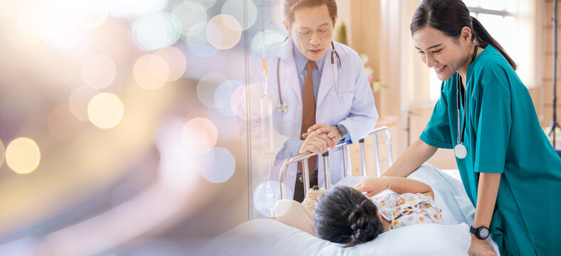 Pediatrician visiting parents and child in hospital bed ward