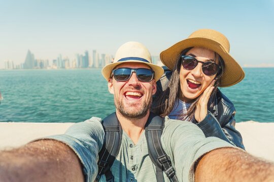 Joyful heterosexual happy couple looking at camera pose smile show happiness taking selfie photo laughing enjoying vacation in DOHA, Qatar. Connection, freedom. Concept safety travel middle east