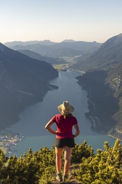 Young hiker, woman looking into the distance, view from B&auml;renkopf mountain to Lake Achen, left Seebergspitze and Seekarspitze, right Rofan Mountains, Tyrol, Austria