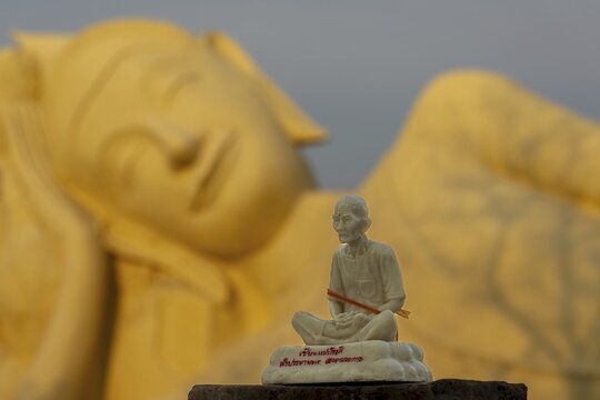 Small stone statue of a meditating monk, Buddha statue behind it, transition to Nirvana, Wat Lokayasutha, Ayutthaya, Thailand